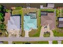 Aerial view of the home with a screened-in pool, canal access, and boat dock at 18662 Arapahoe Cir, Port Charlotte, FL 33948