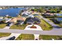 Aerial view of a single-story home in a waterfront community with circle driveway and meticulous landscaping at 20339 Gentry Ave, Port Charlotte, FL 33952