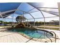 Screened in pool with waterfall feature and rock surround at 20339 Gentry Ave, Port Charlotte, FL 33952