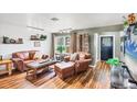 Cozy living room features hardwood floors, a leather sofa and chair, a large window and neutral wall colors at 2082 Broad Ranch Dr, Port Charlotte, FL 33948