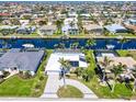 Stunning aerial view of a waterfront home with a private dock, solar panels, and lush landscaping at 2180 Via Esplanade, Punta Gorda, FL 33950