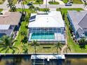 Overhead view showcasing the enclosed pool area, surrounding palm trees, and waterfront access at 2180 Via Esplanade, Punta Gorda, FL 33950