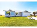 Beautiful one-story home featuring a metal roof, an attached two-car garage, and a lush lawn at 24473 San Rafael Rd, Punta Gorda, FL 33955