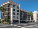 Exterior view of a multi-story condo building with covered parking and well-maintained grounds at 25188 Marion Ave # F303, Punta Gorda, FL 33950