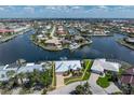 Aerial view of waterfront home with a metal roof and lush landscaping on a canal with a boat dock at 258 Venezia Ct, Punta Gorda, FL 33950
