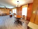 Cozy dining room features wood-paneled walls, hardwood floors, and a chandelier fixture at 6830 Pleasant Ct, North Port, FL 34287