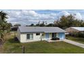 Cozy home featuring a well-kept front lawn, a light yellow exterior, and a clean roof at 821 Bayard St, Port Charlotte, FL 33948