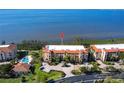Beautiful condo building featuring a pool and lush landscaping with water views at 93 Vivante Blvd # 9323, Punta Gorda, FL 33950