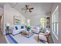 Bright living room featuring vaulted ceiling, large windows, plush white sofa, and stylish decor, creating a comfortable and inviting space at 11401 2Nd Ave, Punta Gorda, FL 33955