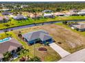 Scenic aerial view of a cozy blue home situated on a waterfront canal with beautifully landscaped surroundings at 149 Sportsman Rd, Rotonda West, FL 33947