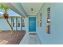 Inviting home entrance with bright blue door, decorative wall art, and smooth walkway surrounded by landscaping at 149 Sportsman Rd, Rotonda West, FL 33947