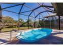 Inviting pool surrounded by stone pavers and a screened enclosure allowing for open views of the landscaped yard at 156 Danforth Dr, Punta Gorda, FL 33980