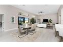 Bright dining area with modern table, seamlessly flowing into the living area and offering backyard views at 16210 Cape Horn Blvd, Punta Gorda, FL 33955