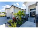 Home's entrance features lush tropical landscaping, adding curb appeal with clean lines and a modern front door at 16210 Cape Horn Blvd, Punta Gorda, FL 33955