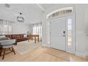 Open foyer with light wood floors flowing into a living room with a leather sofa and foosball table at 17 White Marsh Ln, Rotonda West, FL 33947