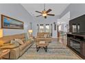 Comfortable living room with high ceilings, a ceiling fan, French doors, and an entertainment center at 24659 Buckingham Way, Punta Gorda, FL 33980