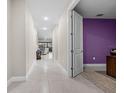 Bright hallway with tile flooring, leading to a living area with a view to the outdoors at 2486 Buckthorn Loop, North Port, FL 34289