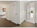 Hallway with storage and neutral carpet leads to an open living space with abundant natural light at 25188 Marion Ave # D303, Punta Gorda, FL 33950