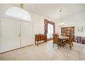 Traditional dining room with chandelier, tiled floor, and decorative window treatment at 26389 Villa Maria Dr, Punta Gorda, FL 33983