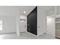 Bright entryway features gray tile flooring, white walls, black accent wall, and a contemporary design at 267 Camrose St, Port Charlotte, FL 33954