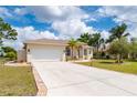 Well-maintained home with spacious driveway, lush lawn and tropical landscaping on a sunny day at 380 Concordia St, Punta Gorda, FL 33983