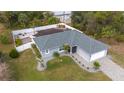 Aerial view of a gray single-story home showcasing a pristine lawn, fenced backyard, and a paved driveway at 4373 Atwater Dr, North Port, FL 34288