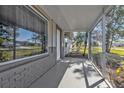 Inviting screened front porch with a gray brick accent wall and view of the landscaping at 628 Tarpon Way, Punta Gorda, FL 33950