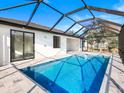 Inviting screened-in pool area featuring a sparkling blue pool and a spacious patio for lounging at 14319 Allensworth Ave, Port Charlotte, FL 33981