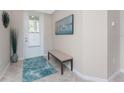 Inviting foyer with neutral walls, artwork, an entry bench, a rug, and a tiled floor at 14640 Sycamore Ct # 2812, Punta Gorda, FL 33955