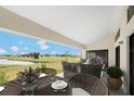 An elegant outdoor dining area overlooking a serene grassy landscape, offering a perfect blend of luxury and nature at 16440 Cape Horn Blvd, Punta Gorda, FL 33955