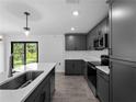Modern kitchen featuring sleek, dark cabinets, stainless steel appliances, and a stylish island at 17331 Elmwood Ave, Port Charlotte, FL 33948