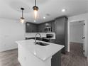 Bright kitchen with gray cabinets, stainless steel appliances, and a functional center island at 17331 Elmwood Ave, Port Charlotte, FL 33948