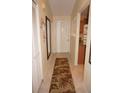 Bright condo hallway featuring tile floors, coat closet, and neutral decor, leading to the living spaces at 220 Coldeway Dr # 123, Punta Gorda, FL 33950
