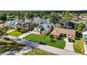 Beautiful home on a lake with mature lawn and landscaping, with a view of surrounding houses at 23240 Fullerton Ave, Punta Gorda, FL 33980