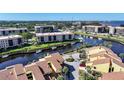 Aerial view of two-story condos featuring waterfront access, boat docks and manicured landscaping at 25188 Marion Ave # 1015, Punta Gorda, FL 33950