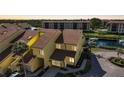 Aerial view of two-story condo featuring a screened garage, lush landscaping, and waterfront access at 25188 Marion Ave # 1015, Punta Gorda, FL 33950