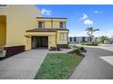 Inviting two-story condo featuring a screened garage, lush landscaping, and a paved driveway on a sunny day at 25188 Marion Ave # 1015, Punta Gorda, FL 33950