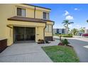 Inviting two-story condo featuring a screened garage, lush landscaping, and a paved driveway on a sunny day at 25188 Marion Ave # 1015, Punta Gorda, FL 33950