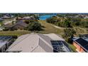 Aerial view of a home with a metal roof, screened in pool, and access to the lake at 26089 Templar Ln, Punta Gorda, FL 33983