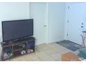 Simple living room featuring tile floors, a modern television, and a neat entertainment console at 3116 Crestwood Dr, Port Charlotte, FL 33952