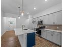Modern kitchen features gray cabinets, stainless appliances, and quartz countertops with a stylish island and pendant lighting at 368 Manly St, Port Charlotte, FL 33953
