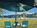 Serene backyard featuring an umbrella, seating, and manicured lawn with stunning views of the canal at 4091 Rock Creek Dr, Port Charlotte, FL 33948