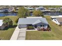 Aerial view of this charming single-story home showcasing a metal roof, a lush front yard, and a long driveway at 4091 Rock Creek Dr, Port Charlotte, FL 33948