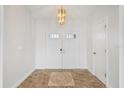 Bright foyer featuring double doors, decorative tile flooring, and a modern chandelier at 7095 Beardsley St, Englewood, FL 34224