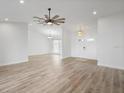 Spacious living room with new flooring and modern ceiling fan, flowing into the entryway and dining room at 7095 Beardsley St, Englewood, FL 34224