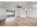 Bright living room featuring updated flooring, a ceiling fan, and sliding glass doors leading to the lanai at 7095 Beardsley St, Englewood, FL 34224