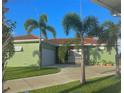 Inviting single-story home showcasing a green exterior, clay tile roof, manicured lawn, and a two-car garage at 1315 Santiago Ct, Punta Gorda, FL 33950