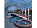 Relaxing screened pool and spa area with an outdoor grill and decorative lighting at 1563 Arundel Ave, North Port, FL 34288