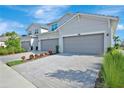 Attractive two-story home featuring a two-car garage, brick driveway and verdant landscaping under clear skies at 15951 Grassland Ln # 3812, Punta Gorda, FL 33982