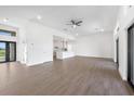 Bright, open-concept living space with light wood floors, featuring a modern kitchen in the background at 17013 Alpenhorn Ct, Punta Gorda, FL 33955